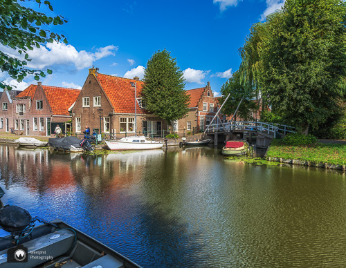 gracht met huizen op de hoek en bruggetje