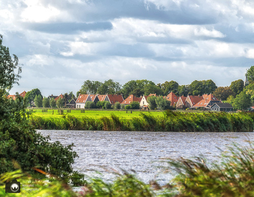woonwijk in de verte met water en groen